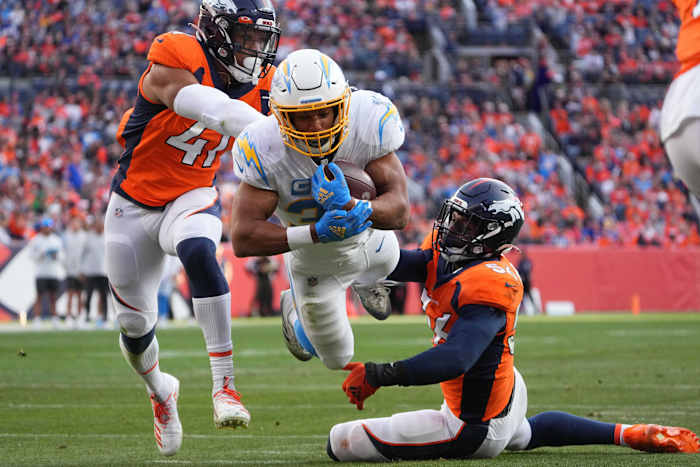 Los Angeles Chargers running back Austin Ekeler (30) dives into the end zone past Denver Broncos inside linebacker Kenny Young (41) and inside linebacker Baron Browning (56) in the second quarter at Empower Field at Mile High.